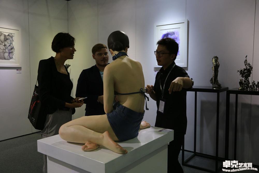 外国艺术家在展览现场就作品《背影》与工作人员交流